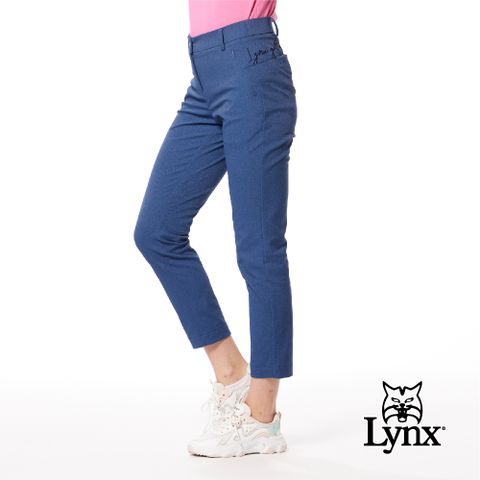 Lynx Golf 女款日本進口布料抗皺彈性舒適丹寧風格織帶剪接設計草寫繡花造型窄管九分褲-深藍牛仔色