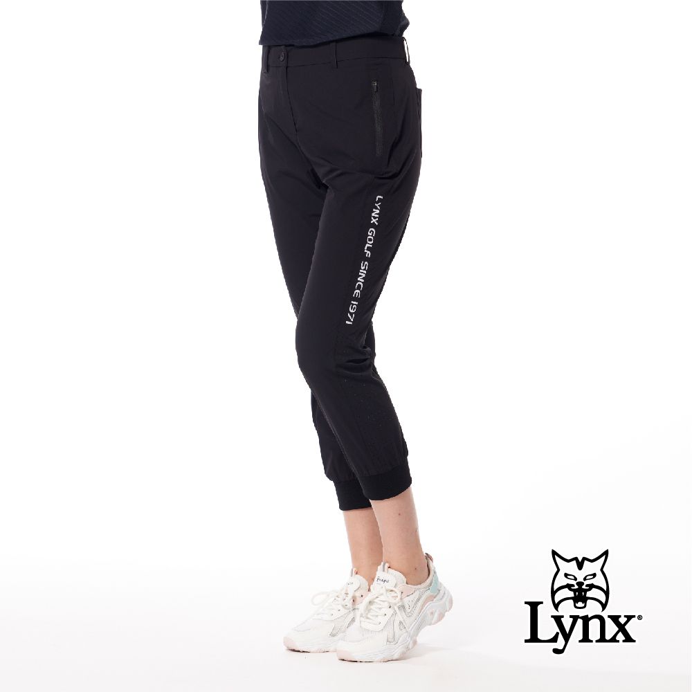 Lynx Golf 首爾高桿風格女款彈性舒適素面LOGO織帶剪接設計拉鍊口袋羅紋縮口窄管九分褲(二色)